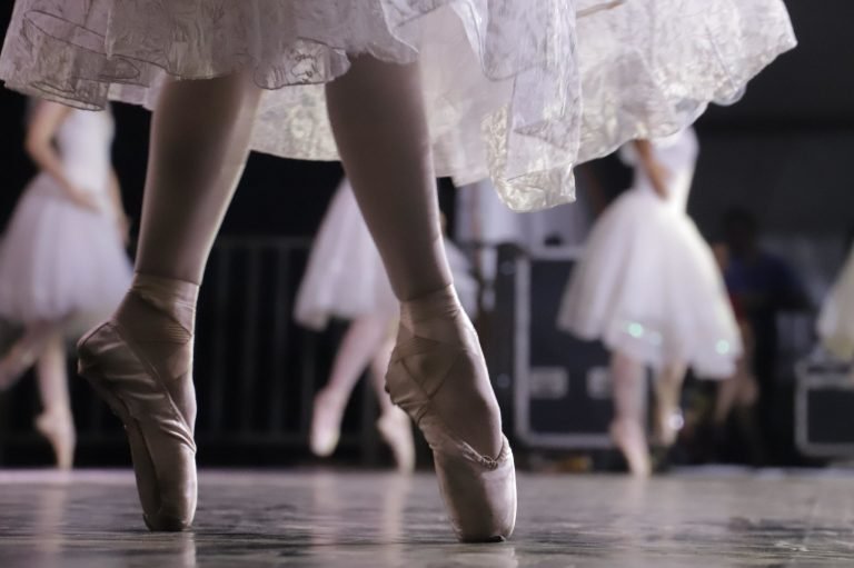 Bailarina na ponta das sapatilhas brancas